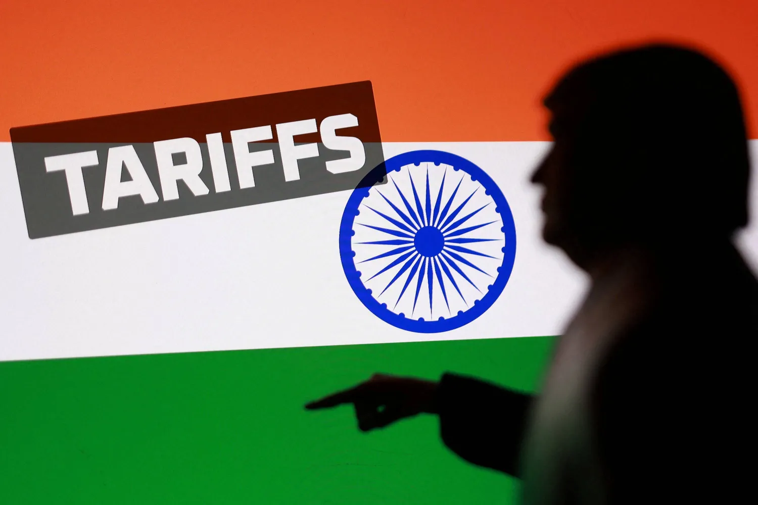 العلم الهندي ونموذج مصغر مطبوع بتقنية الطباعة ثلاثية الأبعاد يُصوّر ترمب وكلمة «رسوم جمركية» (رويترز)