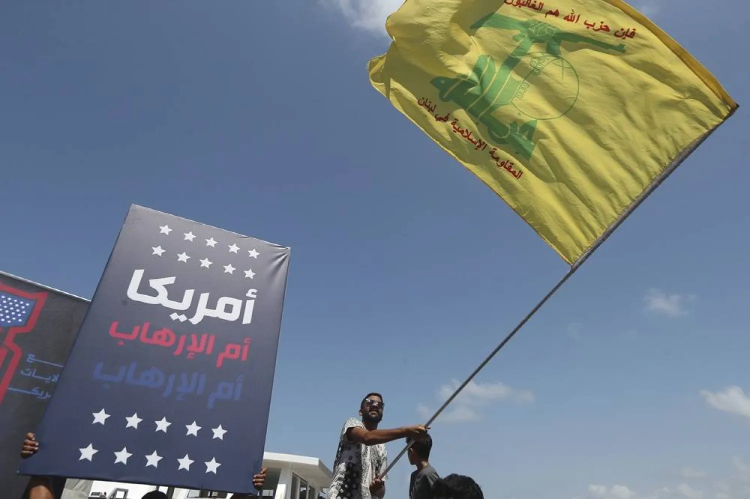  A man waves a Hezbollah flag during a protest against Tom Barrack, US President Donald Trump's envoy to the Middle East, who was supposed to visit Tyre city in south Lebanon, Wednesday, Aug. 27, 2025. (AP)