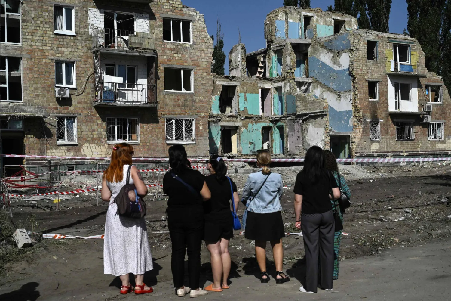 سكان يعاينون الأحد مبنى تضرر قبل 3 أيام خلال هجوم روسي واسع النطاق في كييف (أ.ف.ب)
