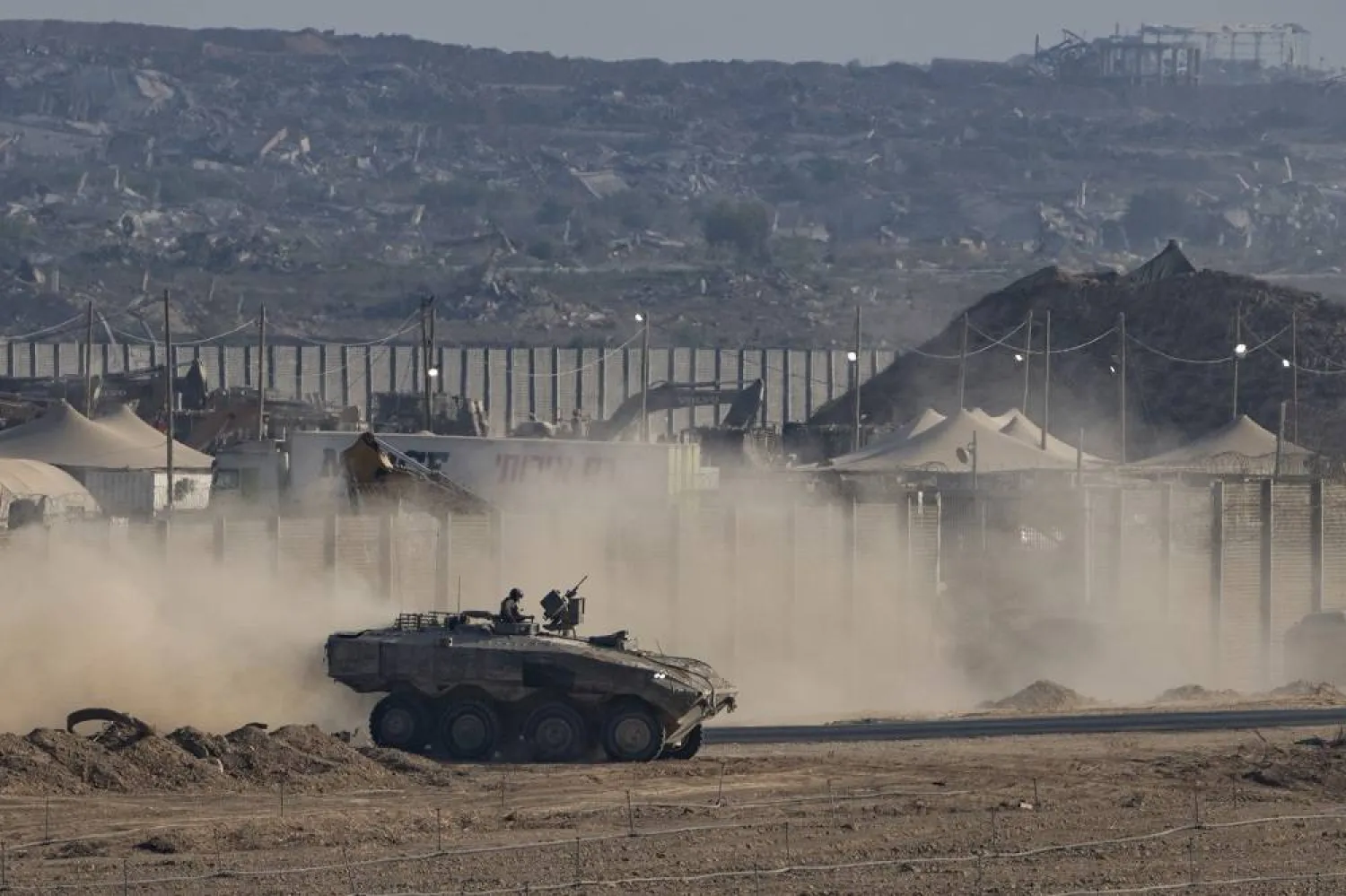 An Israeli soldier moves on top of an armored vehicle near the Israeli-Gaza border, as seen from southern Israel, Sunday, Aug. 31, 2025. (AP)