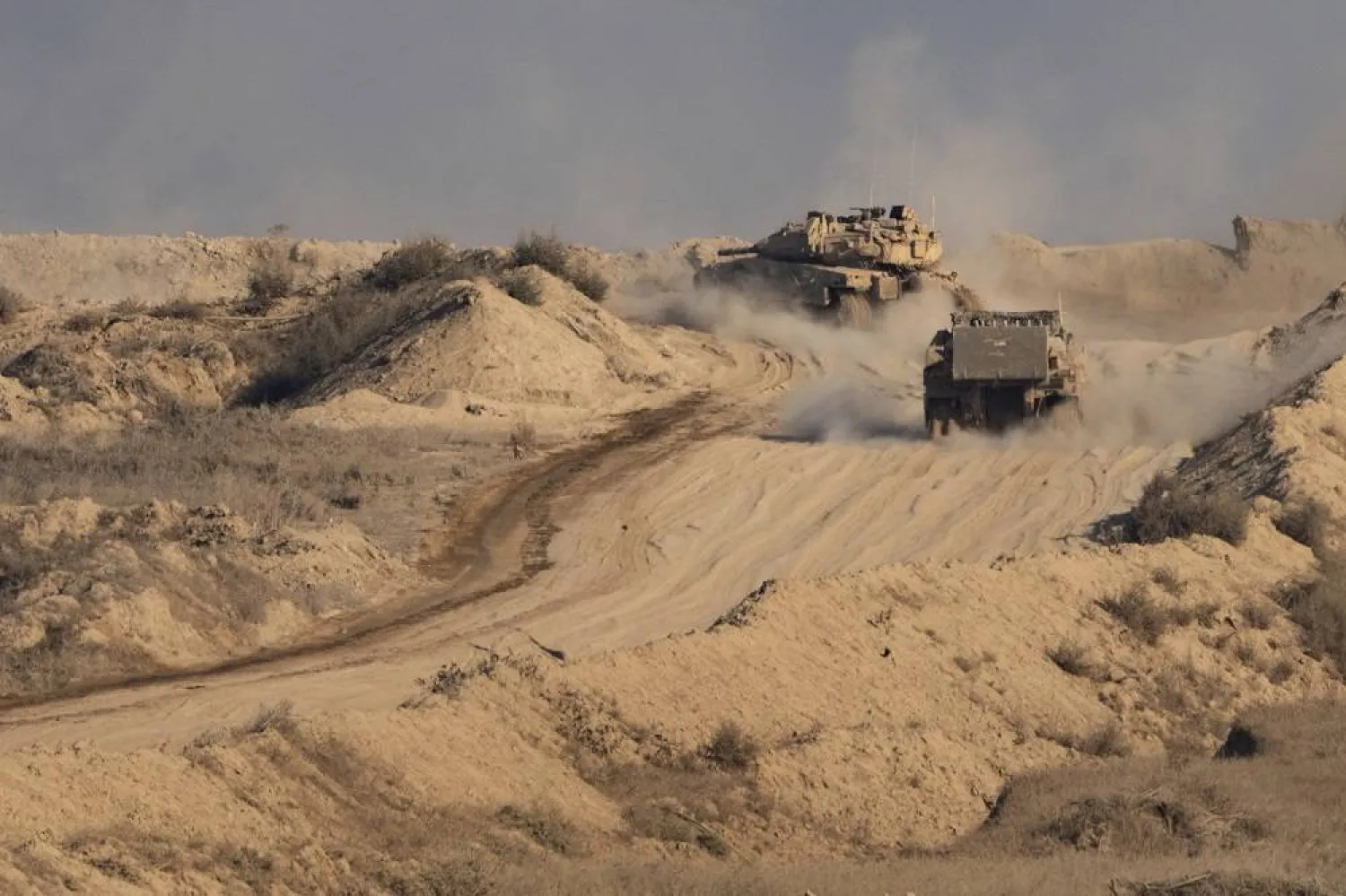 An Israeli tank and an armored personnel carrier (APC) move through an area of the Gaza Strip, as seen from southern Israel, Sunday, Aug. 31, 2025. (AP)