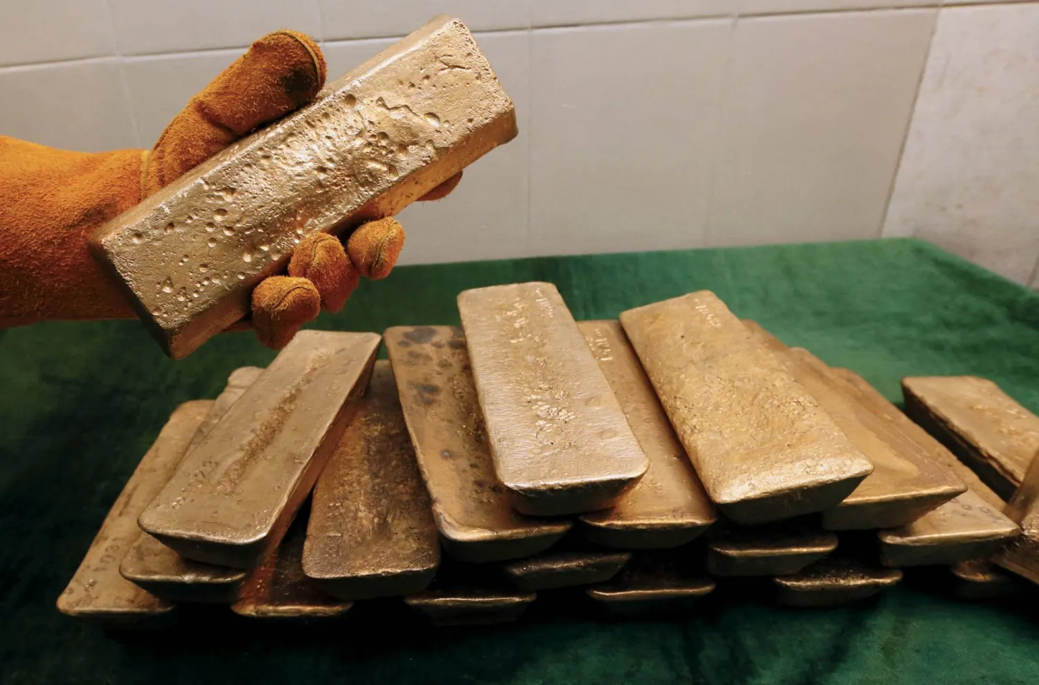 FILE PHOTO: A melter places an ingot of 92.96 percent pure gold at a procession plant of the Olimpiada gold operation, owned by Polyus Gold International company, in Krasnoyarsk region, Eastern Siberia, Russia, June 30, 2015. REUTERS/Ilya Naymushin/File Photo