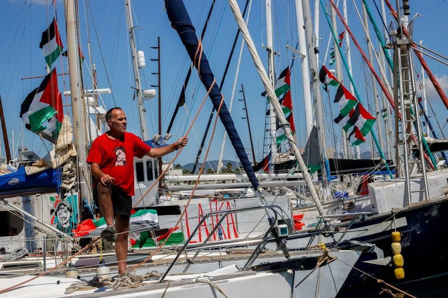 An activist stands on a sailboat from the Global Sumud Flotilla humanitarian expedition as it prepares to set sail for Gaza at the port of Barcelona, Spain, August 30, 2025. (Reuters)