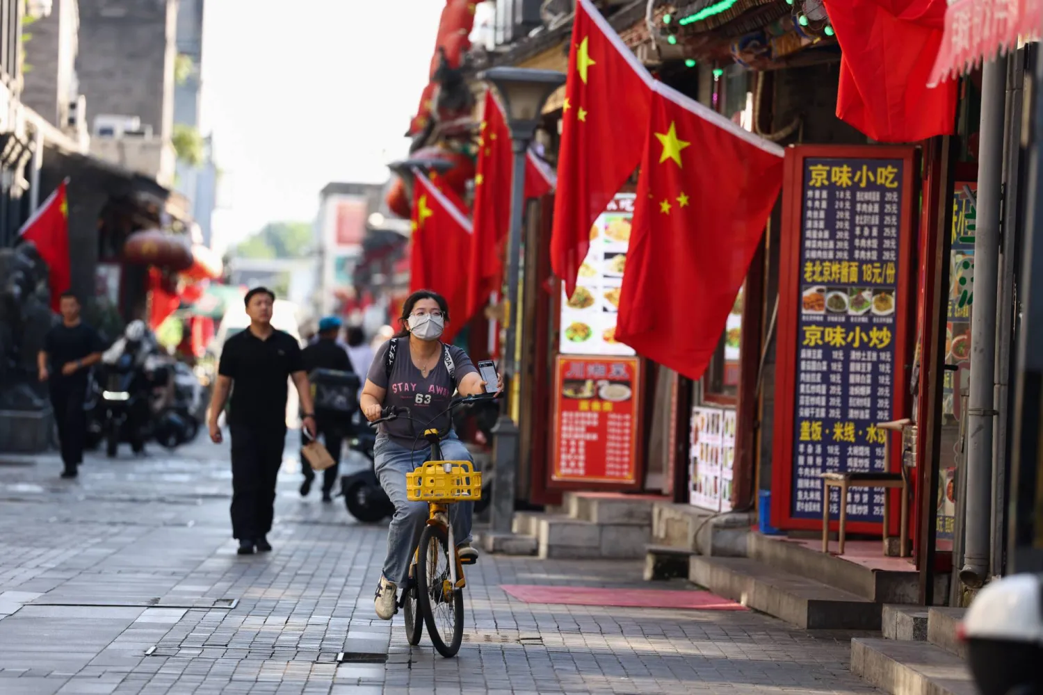 مشاة في أحد الأحياء القديمة بالعاصمة الصينية بكين (إ.ب.أ)