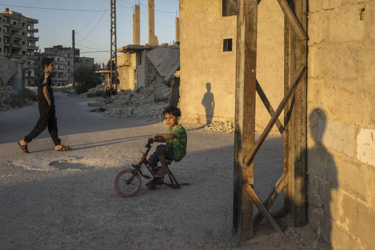 صبي يركب دراجة هوائية متضررة في حيٍّ تضرر جراء الحرب في داريا، إحدى ضواحي دمشق (نيويورك تايمز)