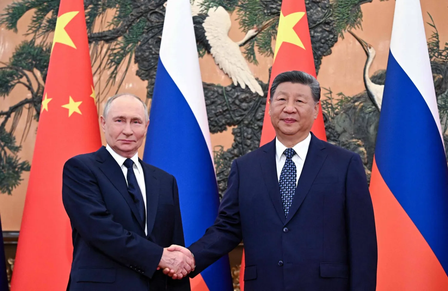 In this pool photograph distributed by the Russian state agency Sputnik, Russia's President Vladimir Putin (L) shakes hands with China's President Xi Jinping during a meeting in Beijing on September 2, 2025. (Photo by Sergey Bobylev / POOL / AFP)