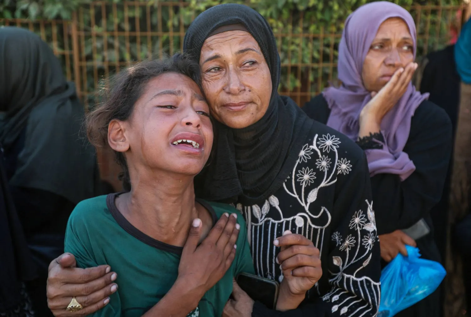 أقارب بعض الضحايا يبكون ذويهم في جنازة بخان يونس (رويترز)