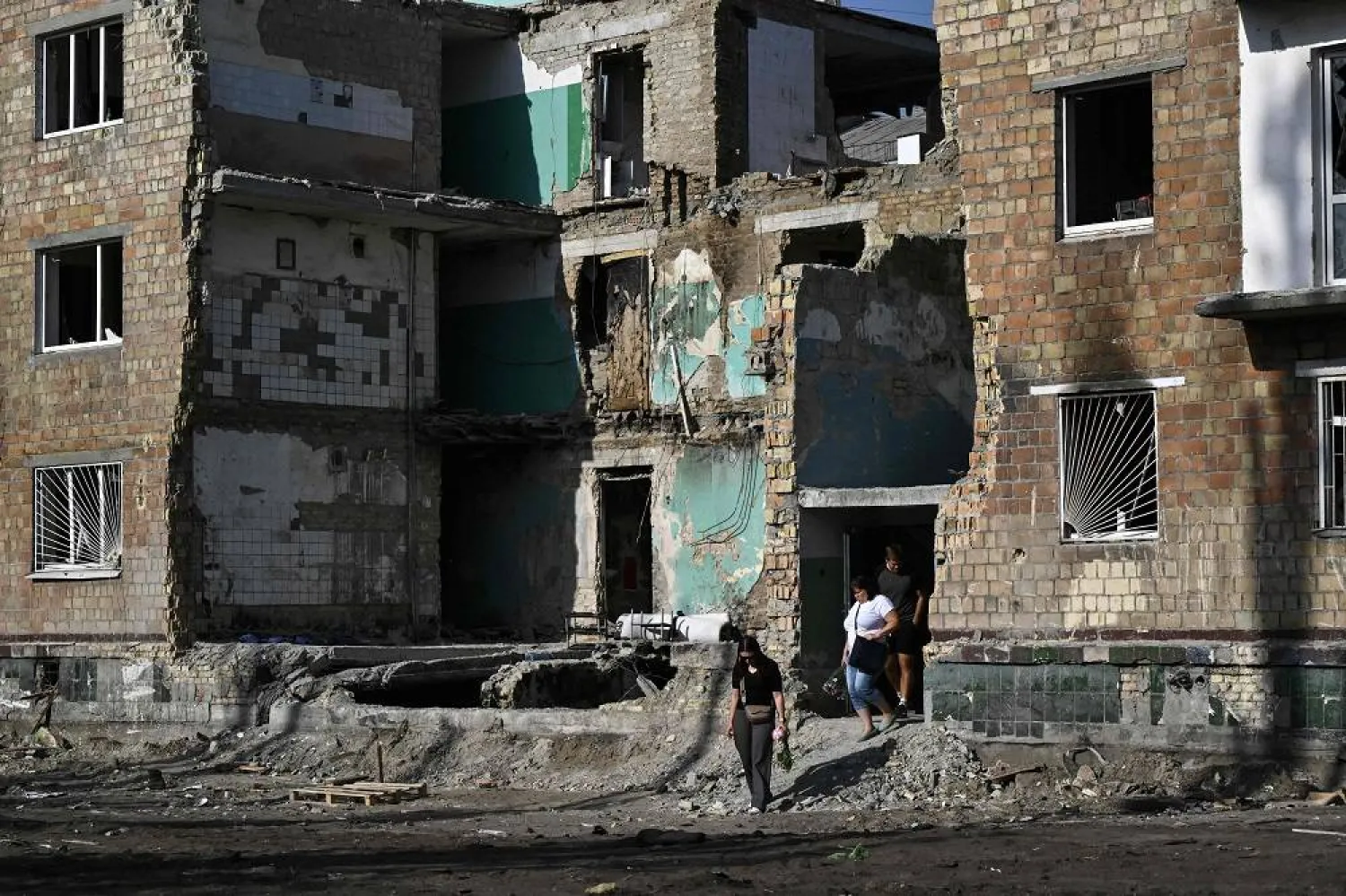 Local residents walk out of the residential building heavily damaged three days ago during a large-scale Russian drone and missile attack, in Kyiv on August 31, 2025, amid the Russian invasion of Ukraine. (AFP)