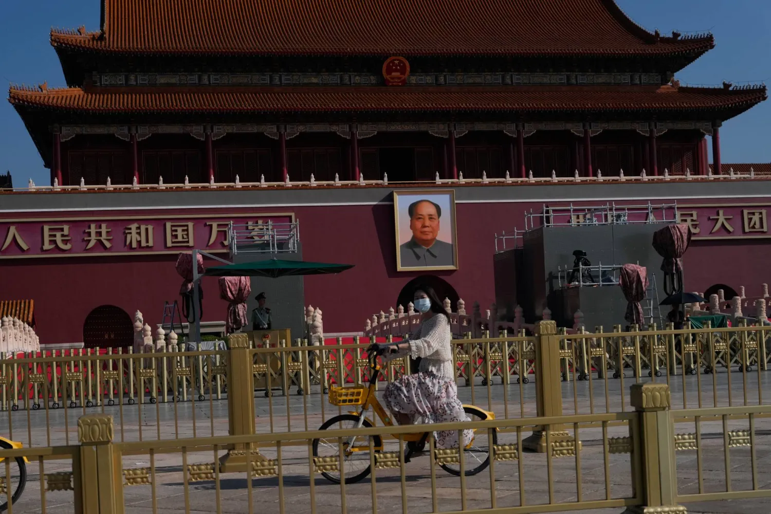 سيدة على دراجة تمر بجانب بوابة تيانانمن قبل العرض العسكري المرتقب غداً (أ.ب) 