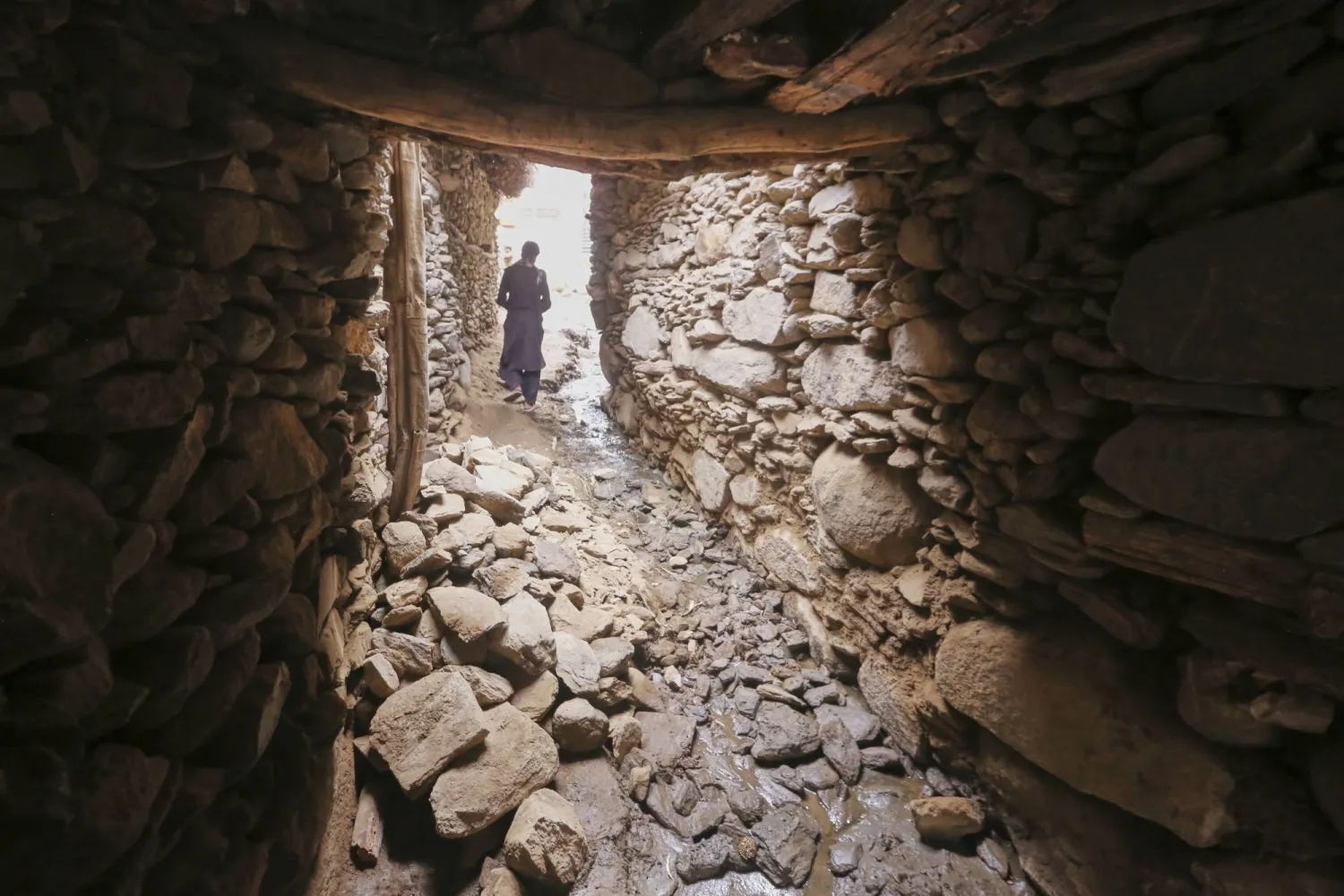 أحد السكان المحليين يسير بجوار جدار منهار جزئياً في دارا نور بولاية كونار - أفغانستان - الثلاثاء 2 سبتمبر 2025 بعد زلزال الأحد المدمر الذي بلغت قوته 6.0 درجة ودمر قرى في شرق البلاد (أ.ب)