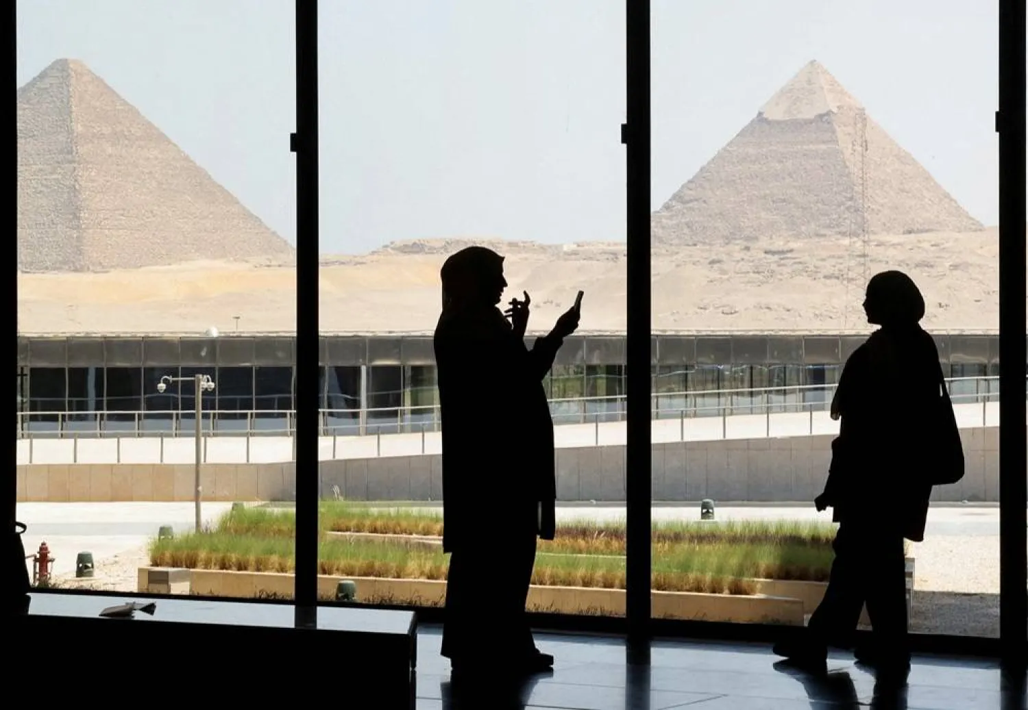 Egyptians take pictures with the pyramids in the background as they visit the Grand Egyptian Museum on the southwestern outskirts of the capital Cairo, Egypt, June 2, 2025. (Reuters)