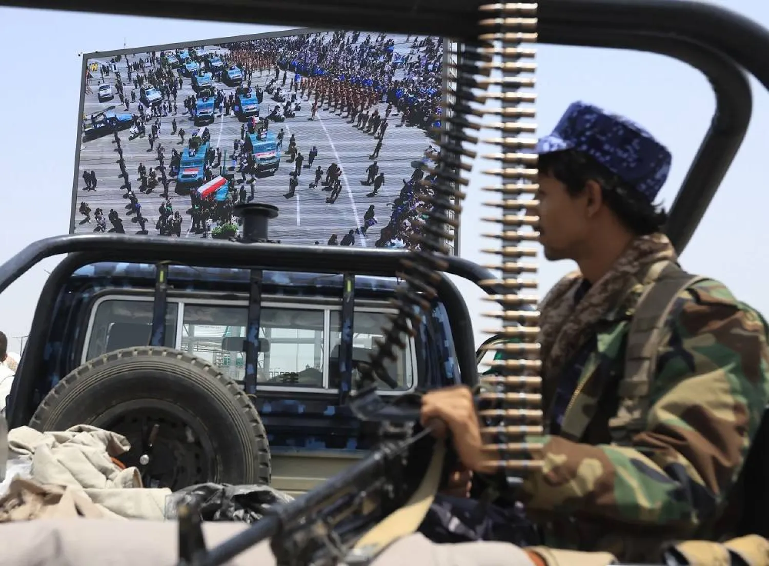 A Houthi fighter rides a pick-up truck while on patrol as a digital billboard features military vehicles carrying the coffins of senior Houthi officials who were killed in recent Israeli strikes, during a funeral in Sanaa, Yemen, 01 September 2025. (EPA)