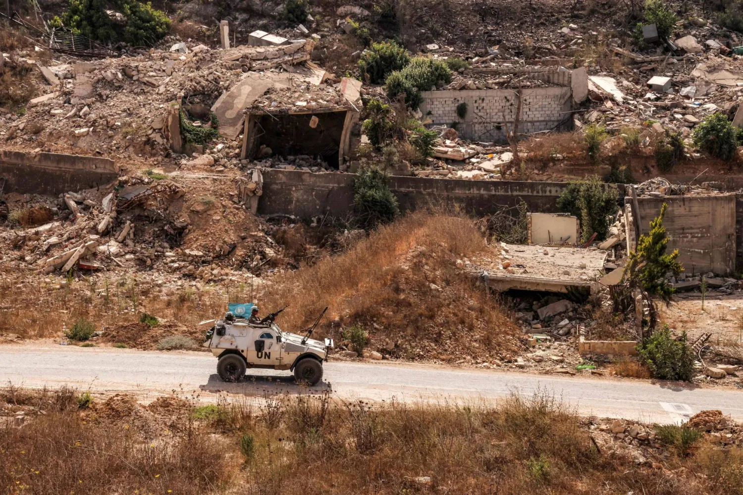 آلية عسكرية لـ«اليونيفيل» تسير قرب منازل مدمرة في كفركلا بجنوب لبنان (أ.ف.ب)