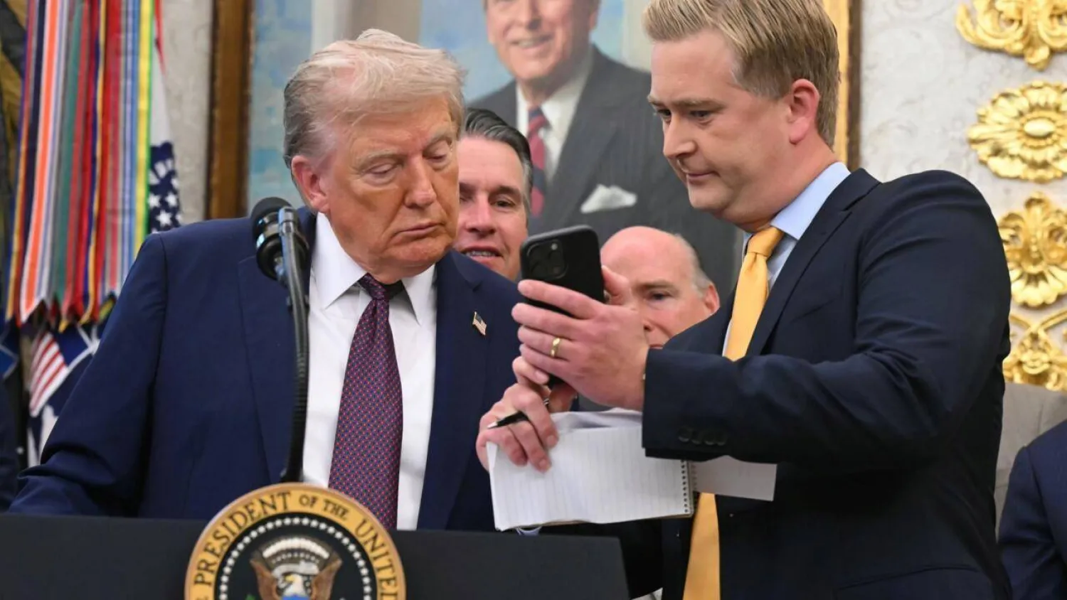 Fox News reporter Peter Doocy shows US President Donald Trump his phone during an Oval Office press conference. SAUL LOEB / AFP
