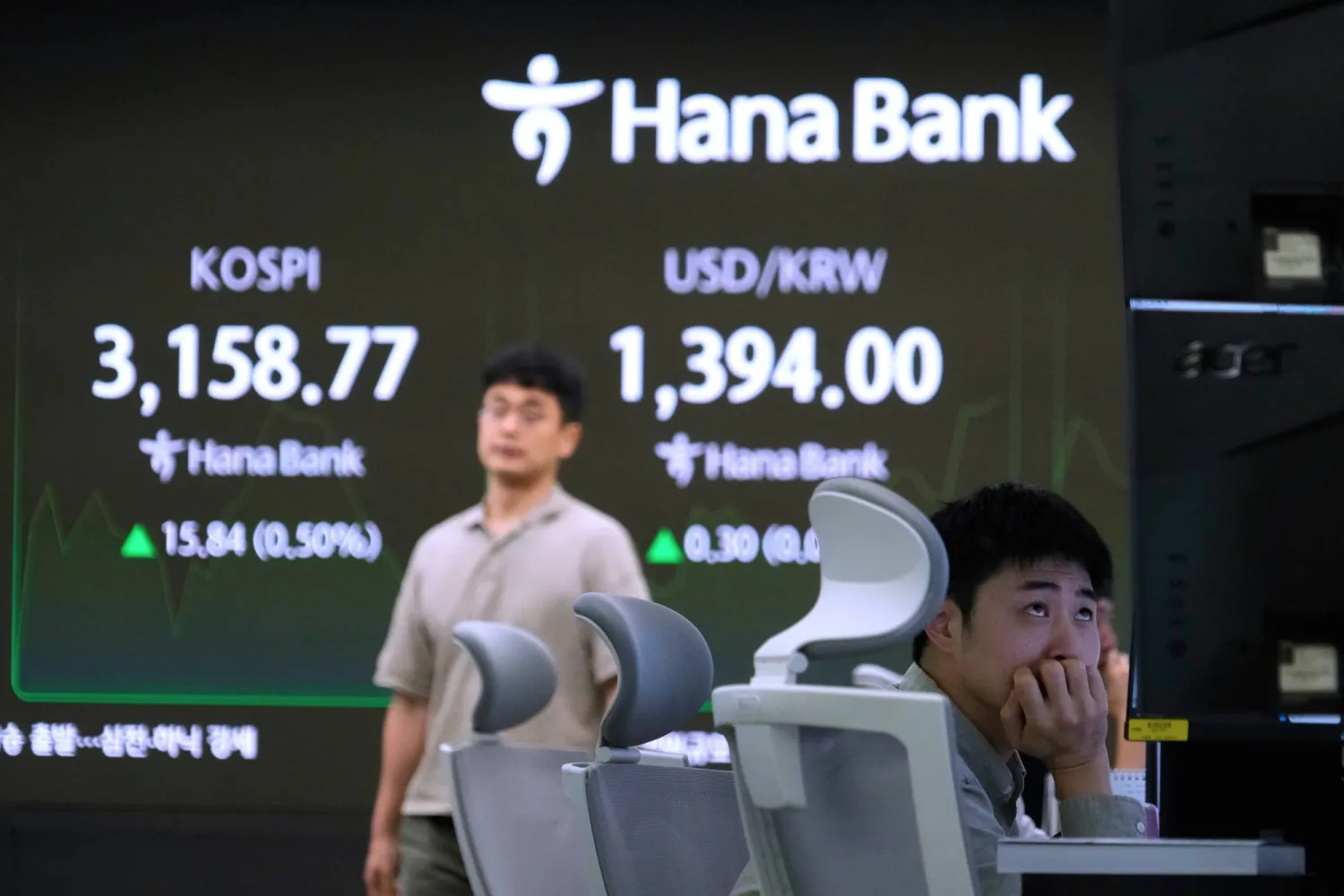 متداولون يتابعون مؤشر «كوسبي» وسعر صرف الدولار مقابل الوون في مقر بنك «هانا» بسيول (أ.ب)
