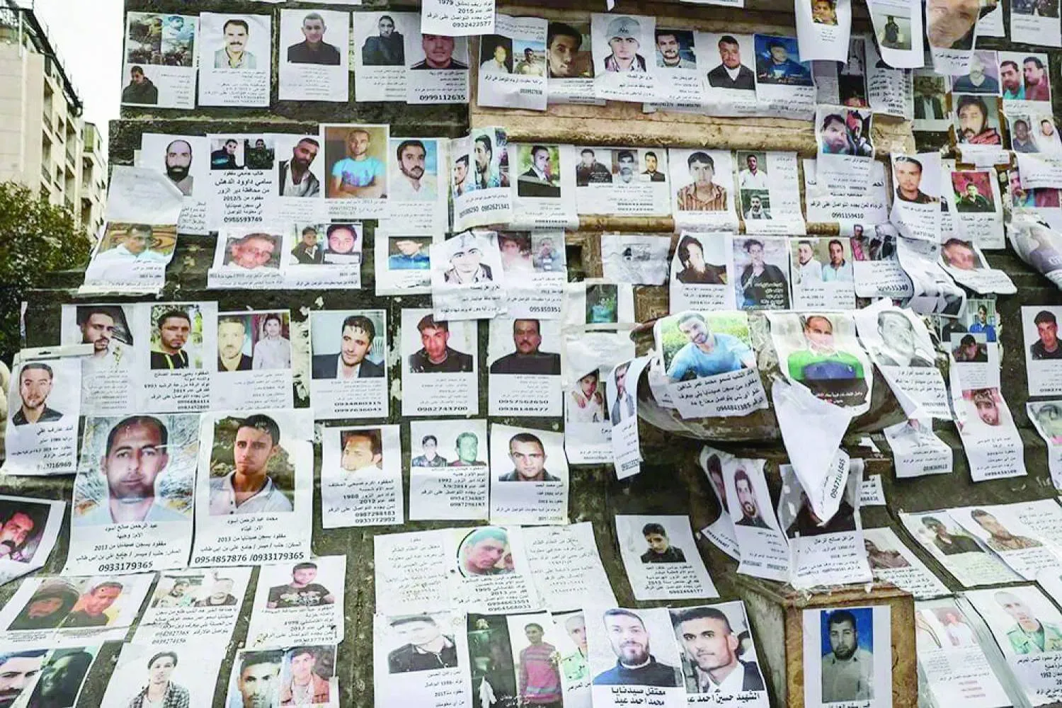 صور لمفقودين يُعتقد أنهم كانوا في سجن «صيدنايا» معلّقة بساحة المرجة وسط دمشق (أرشيفية - رويترز)