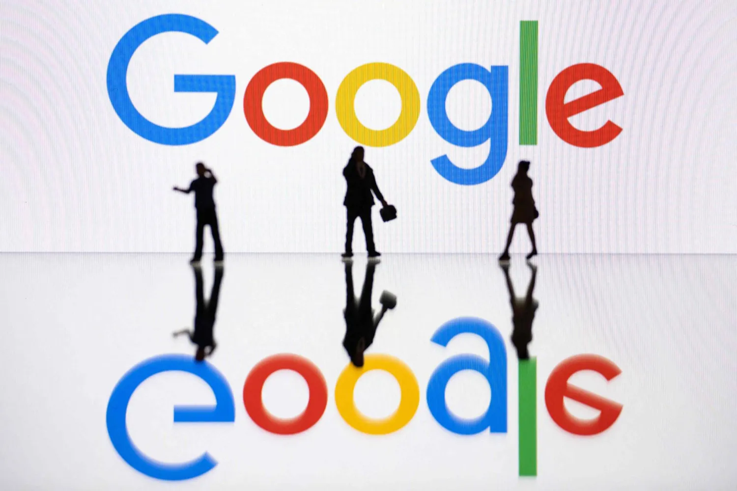 (FILES) This illustration photograph taken on October 30, 2023, in Mulhouse, eastern France, shows figurines next to a screen displaying a logo of Google, a US multinational technology company. (Photo by SEBASTIEN BOZON / AFP)