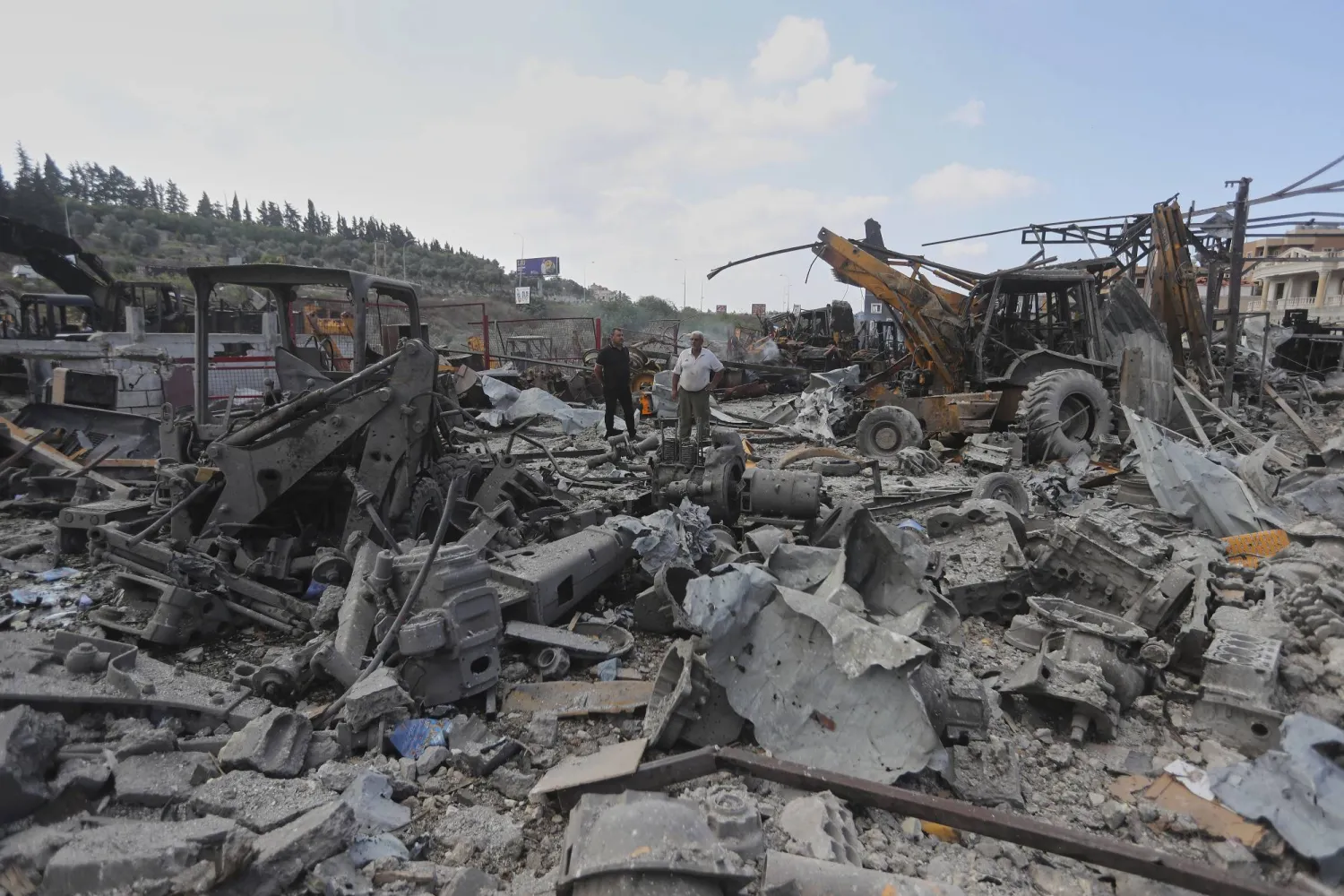 Lebanese people inspect the site where Israeli airstrikes on Wednesday night hit bulldozers in Ansariyeh village, south Lebanon, Thursday, Sept. 4, 2025. (AP Photo/Mohammed Zaatari)