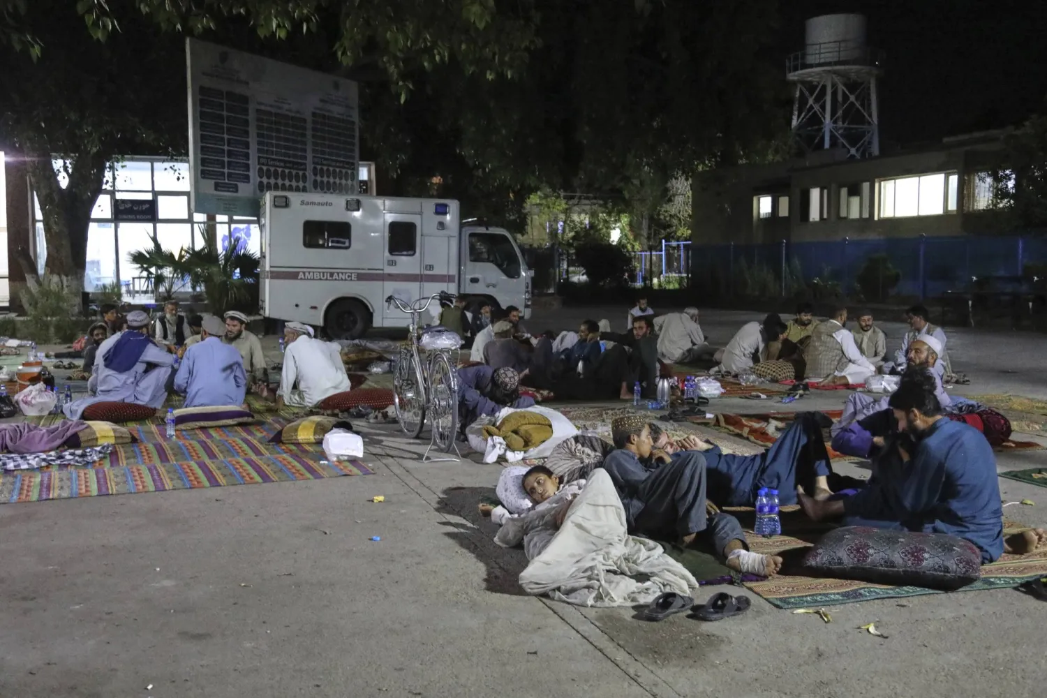 الأفغان المتضررون من الزلزال القوي الذي ضرب شرق أفغانستان يوم الأحد يستريحون خارج مستشفى ننكرهار الإقليمي في جلال آباد الأربعاء (أ.ب)