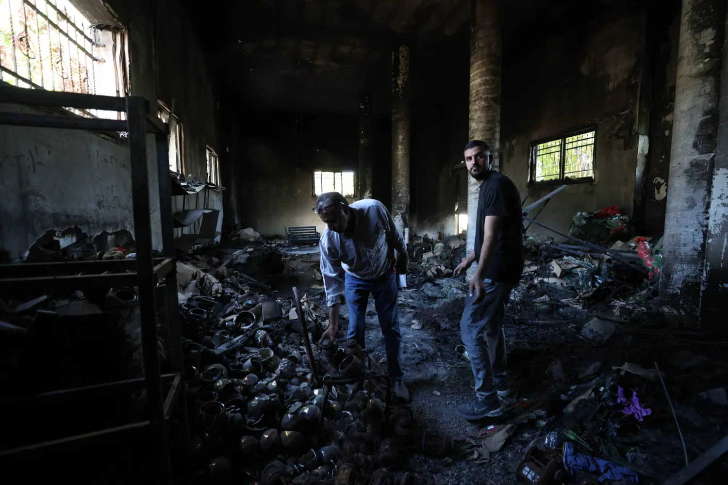 فلسطيني يتفقد الأضرار التي لحقت بمتجره بعد انسحاب القوات الإسرائيلية من مخيم طولكرم للاجئين بالقرب من مدينة طولكرم بالضفة الغربية (إ.ب.أ)