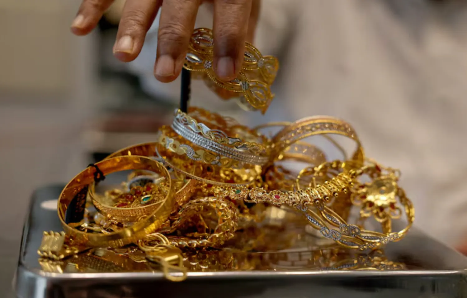 A goldsmith weighs gold jewellery inside a showroom in Ahmedabad, India, July 31, 2025. REUTERS/Amit Dave/File Photo 