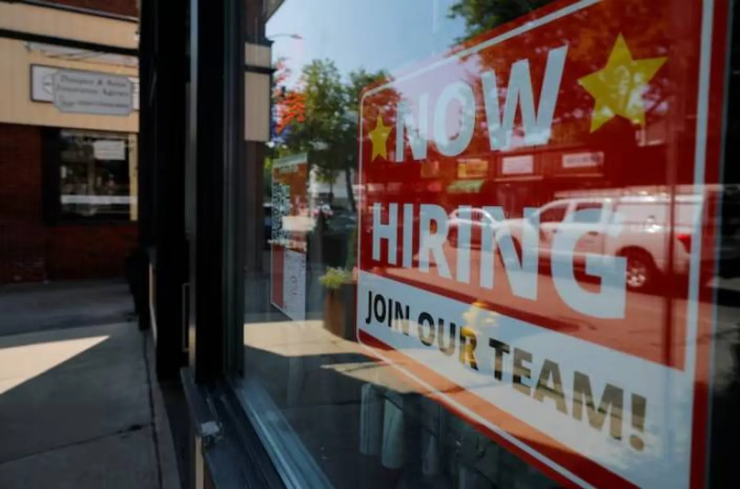 لافتة «مطلوب موظفون» معلّقة على نافذة صالون تجميل في مدينة ميدفورد بولاية ماساتشوستس (رويترز)