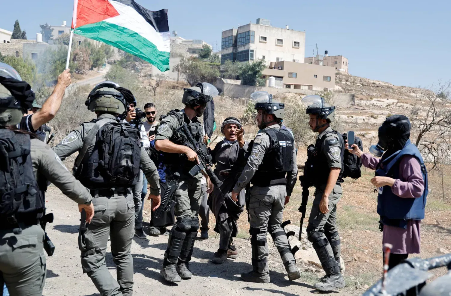 Filistinliler, işgal altındaki Batı Şeria'nın Nablus kenti yakınlarında İsrail yerleşimlerine karşı düzenlenen bir protesto sırasında birbirleriyle etkileşim kuruyorlar (Reuters- Arşiv)
