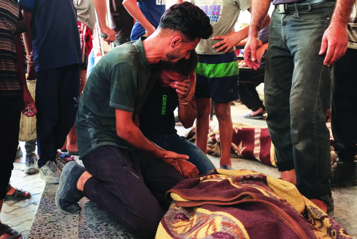 
فلسطينيون يبكون فوق جثمان رجل قُتل في غارة إسرائيلية على مدينة غزة أمس (رويترز)