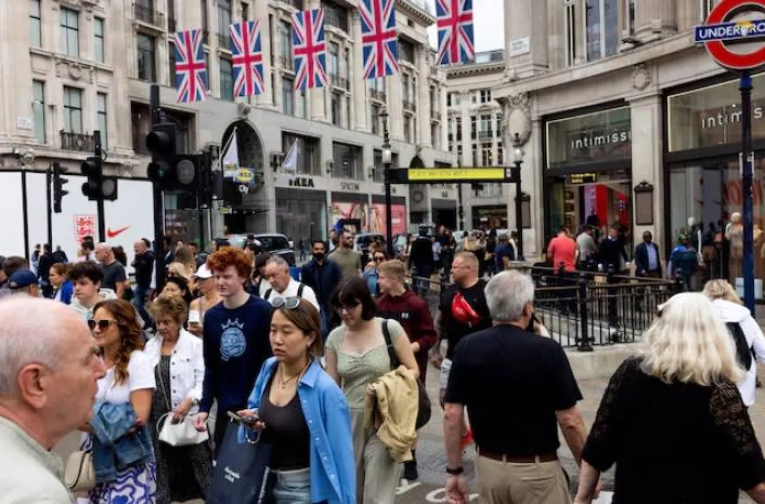 أشخاص ومتسوقون يعبرون شارع أوكسفورد سيركس في لندن (رويترز)