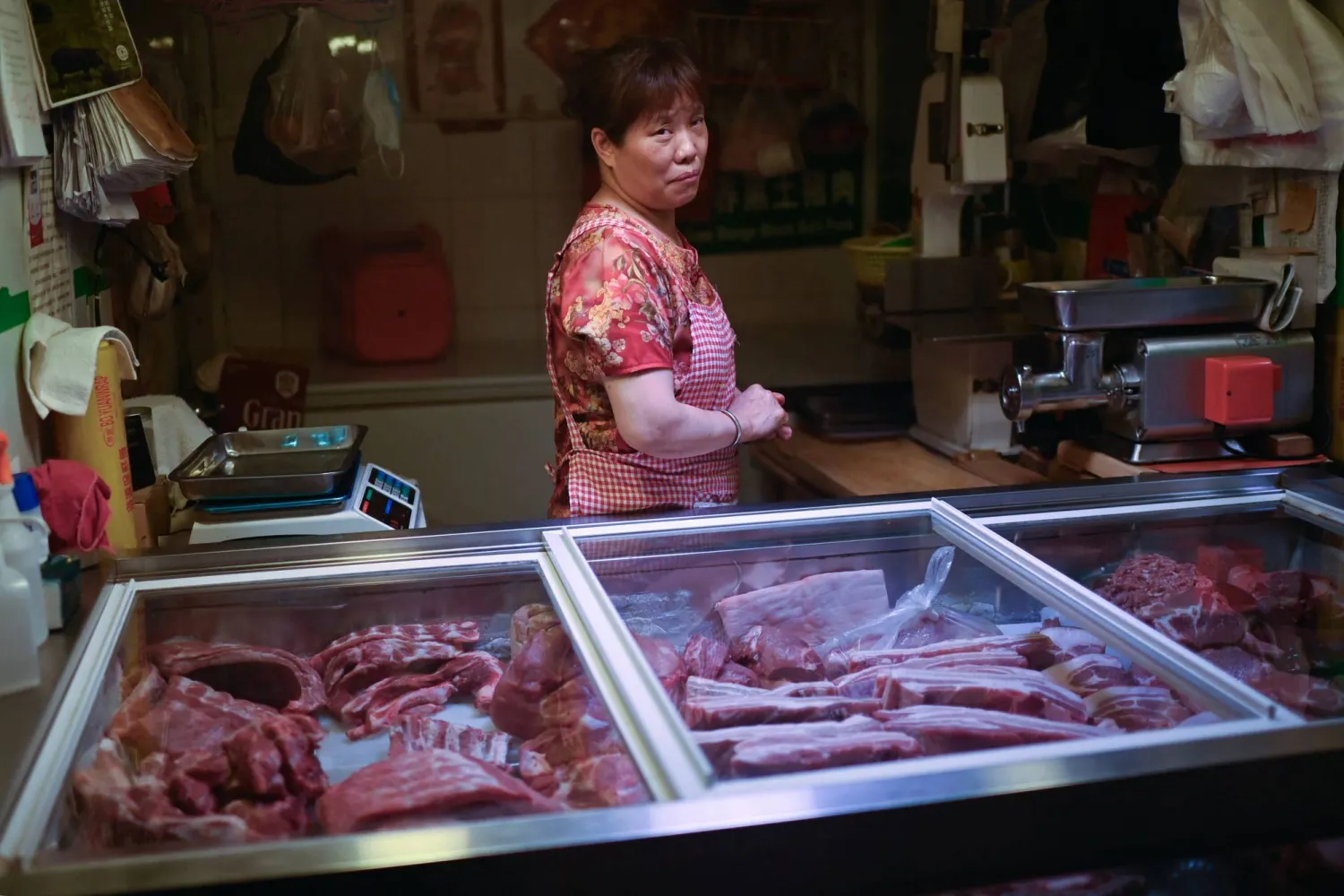 امرأة تعرض لحوم خنزير في متجر وسط العاصمة الصينية (أ.ف.ب)