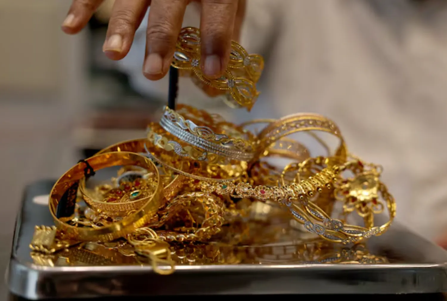 A goldsmith weighs gold jewellery inside a showroom in Ahmedabad, India, July 31, 2025. REUTERS/Amit Dave/File Photo 