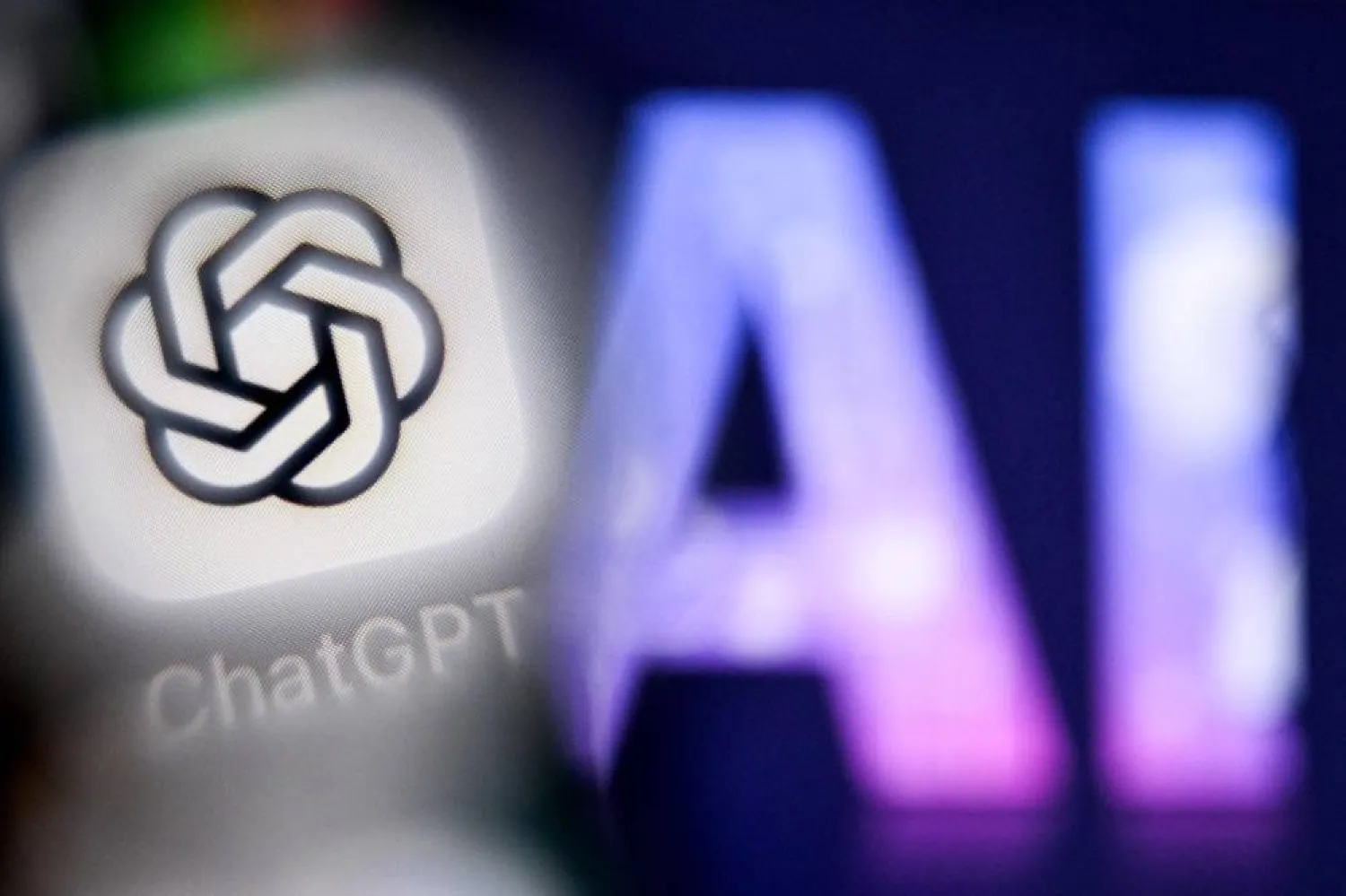 A photo taken on September 1, 2025 shows the letters AI for Artificial Intelligence on a laptop screen (R) next to the logo of the ChatGPT application on a smartphone screen in Frankfurt am Main, western Germany. (AFP)