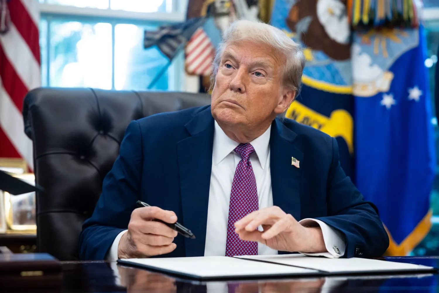 الرئيس الأميركي دونالد ترمب يوقع أمراً تنفيذياً في البيت الأبيض (إ.ب.أ)