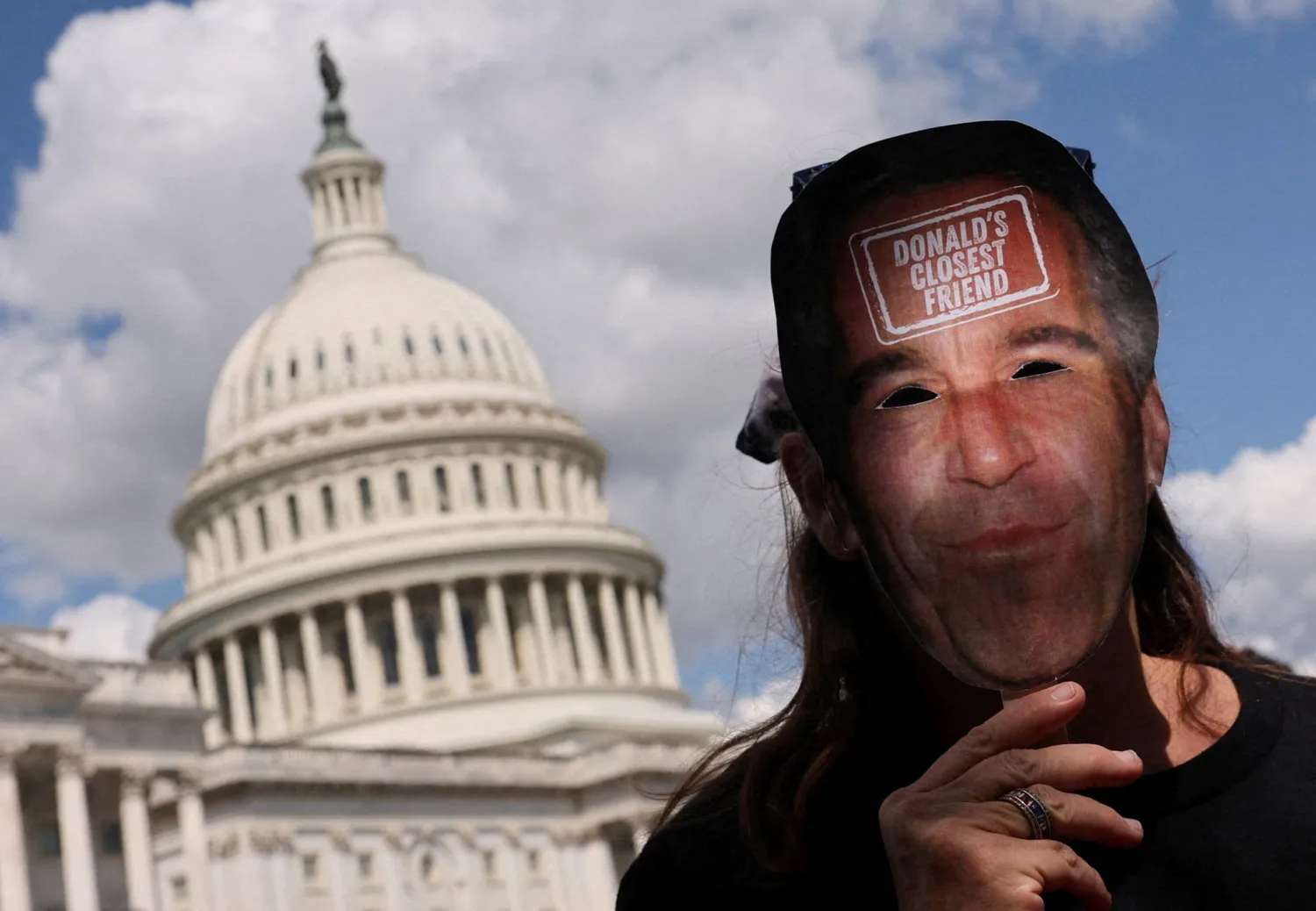 متظاهر مناهض لترمب يحمل قناعاً يصور جيفري إبستين يسير في مبنى الكابيتول الأميركي بواشنطن (رويترز)