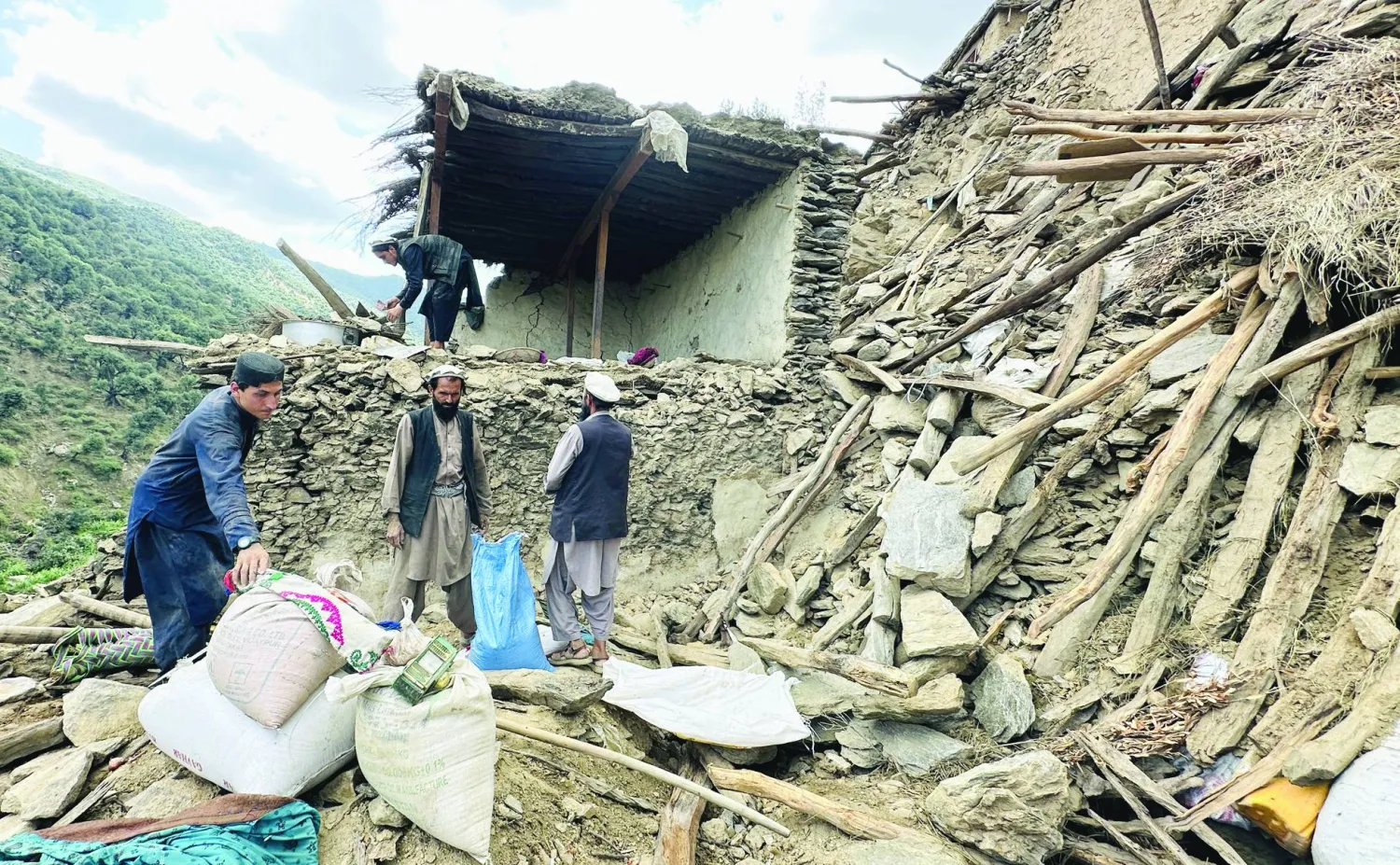 Afghan local Hamidullah (top, rear) salvages belongings as he surveys his damaged house in Kunar, Afghanistan, 04 September 2025 (issued 05 September 2025). EPA/HAMID SABAWOON