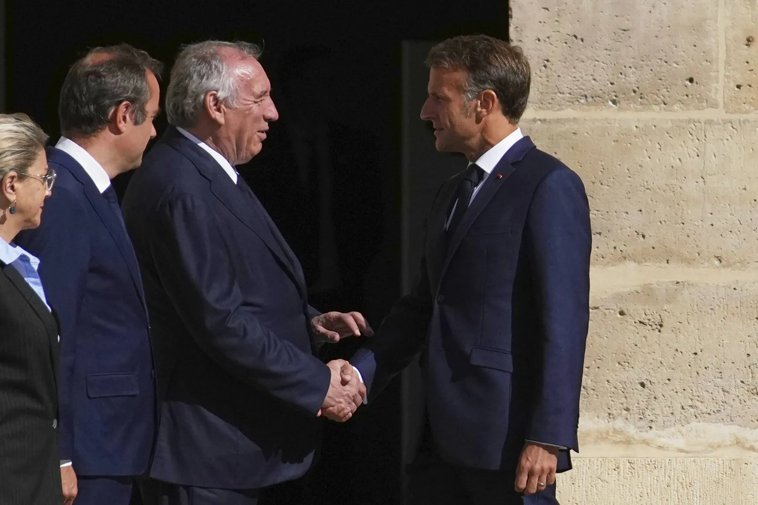 الرئيس الفرنسي إيمانويل ماكرون يصافح رئيس الوزراء فرنسوا بايرو (أ.ب)