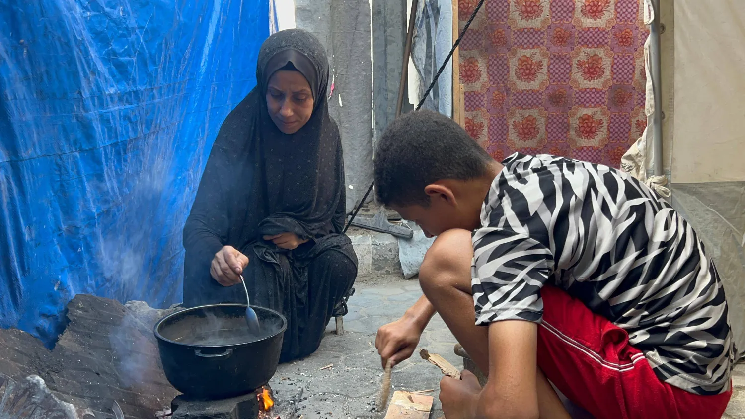 أم وطفلها في خيمة للنازحين قرب مدينة غزة (الشرق الأوسط)