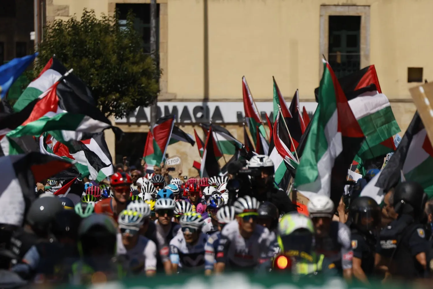 متظاهرون يرفعون أعلام فلسطين خلال إحدى مراحل «سباق إسبانيا للدراجات» (إ.ب.أ)