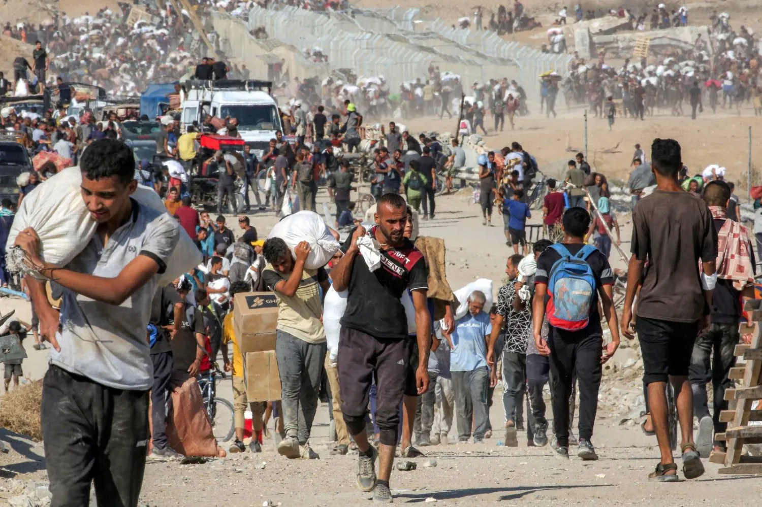 فلسطينيون يحملون أكياساً من المساعدات الإنسانية جنوب قطاع غزة (أ.ف.ب)