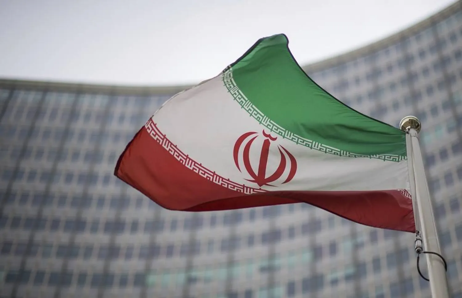 A national flag of Iran waves in front of the building of the International Atomic Energy Agency, IAEA, in Vienna, Austria, Friday, Dec. 17, 2021. (AP)