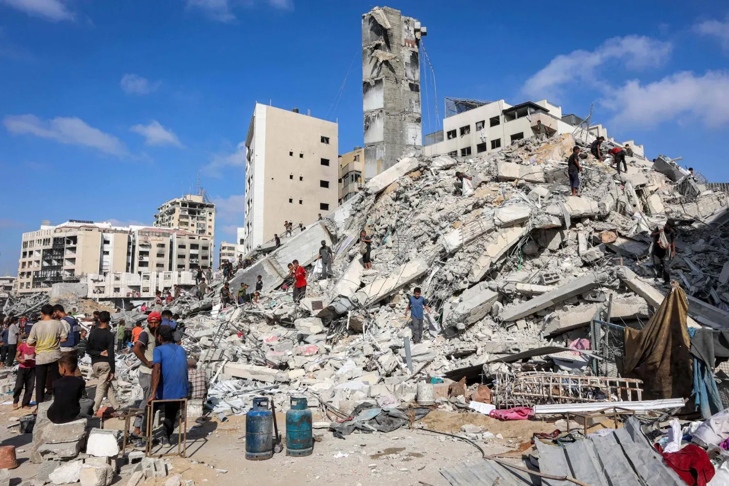 Dün İsrail'in hava saldırısı düzenlediği Gazze şehrindeki es-Susi Binası’nın enkazında arama yapan Filistinliler (AFP)