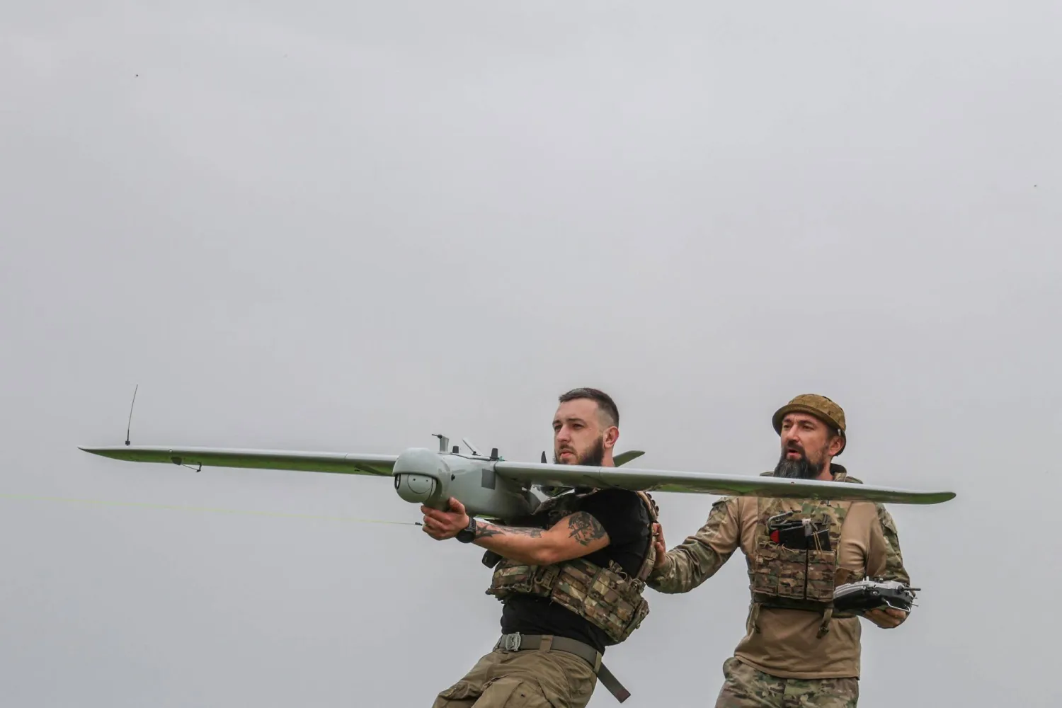 جنديان أوكرانيان يطلقان طائرة استطلاع مسيّرة قرب الجبهة في دونيتسك (رويترز)