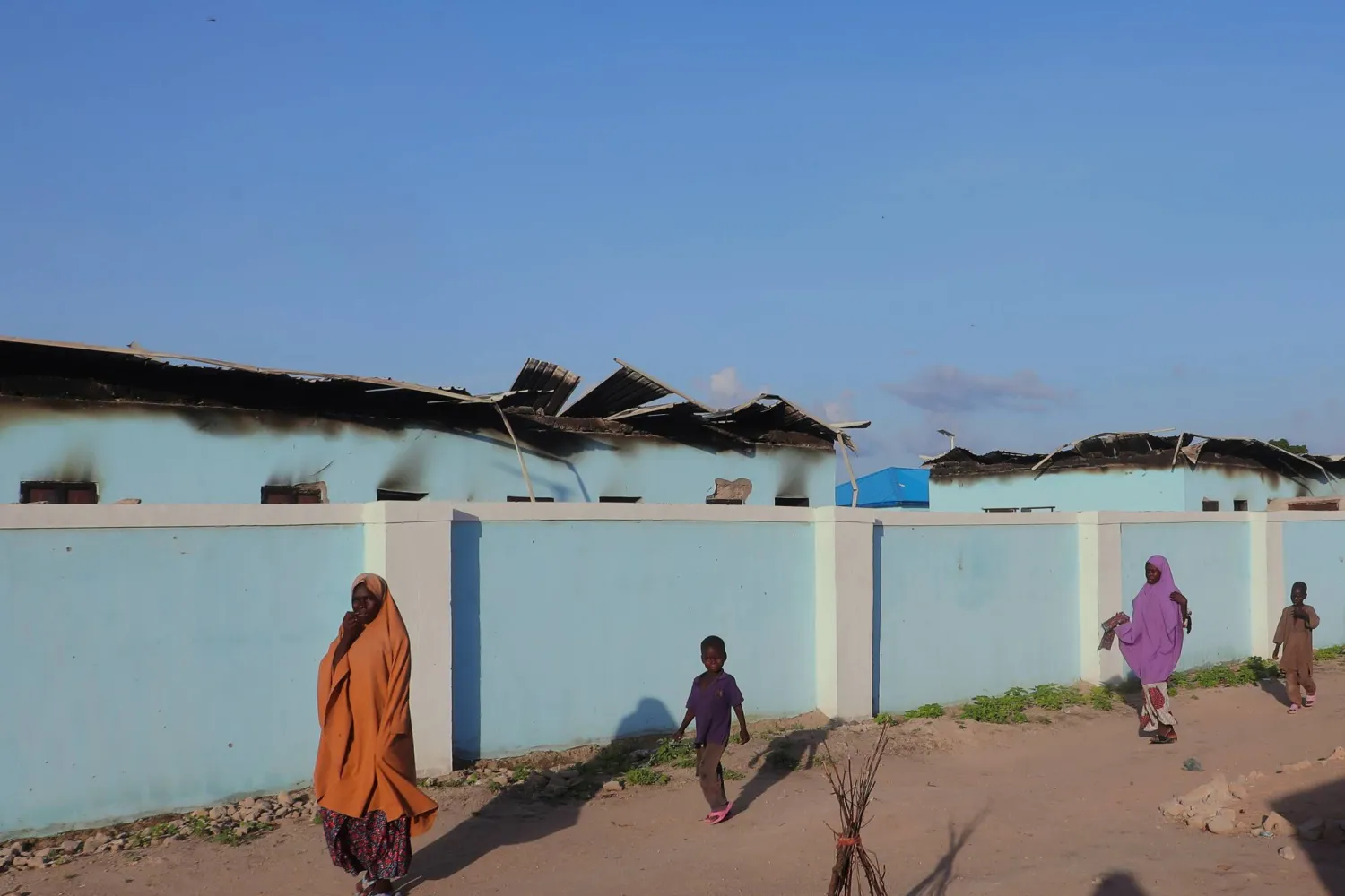 أشخاص يسيرون أمام منازل محترقة بعد هجوم شنته جماعة «بوكو حرام» في دار الجمال... نيجيريا السبت 6 سبتمبر 2025 (أ.ب)