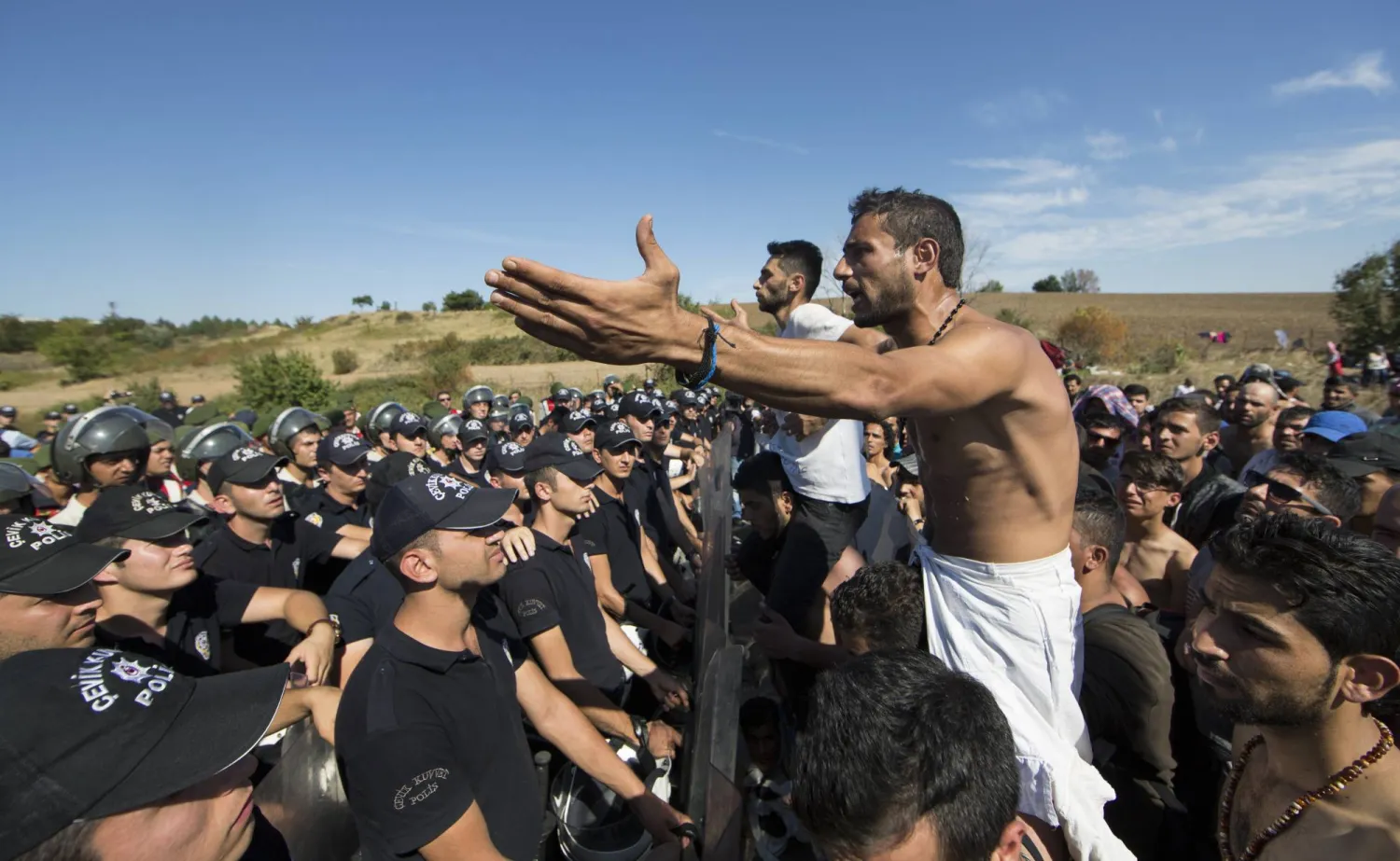 اللاجئون السوريون أمام الشرطة التركية 19 سبتمبر 2015 على الطريق السريع بين إسطنبول وأدرنة ينتظرون الحصول على إذن لعبور الحدود التركية اليونانية في أدرنة (أرشيفية-إ.ب.أ)