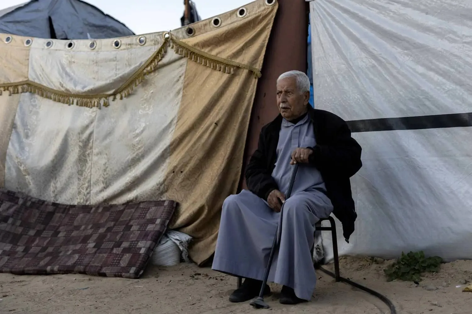 Abdallah Abu Samra in front of the tent where he lives in Khan Yunis, southern Gaza, in February (Saher Alghorra for The New York Times) 