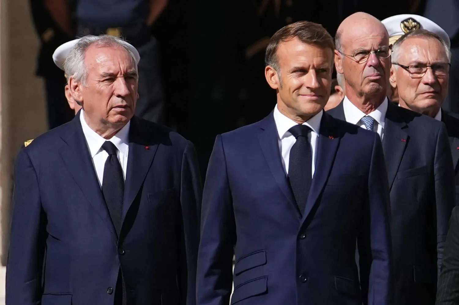 France's Prime Minister Francois Bayrou (L) and France's President Emmanuel Macron attend a farewell to arms ceremony for former chief of staff of France's armed forces Thierry Burkhard in the courtyard of the Hotel des Invalides in Paris on September 5, 2025. (Photo by Christophe Ena / POOL / AFP)