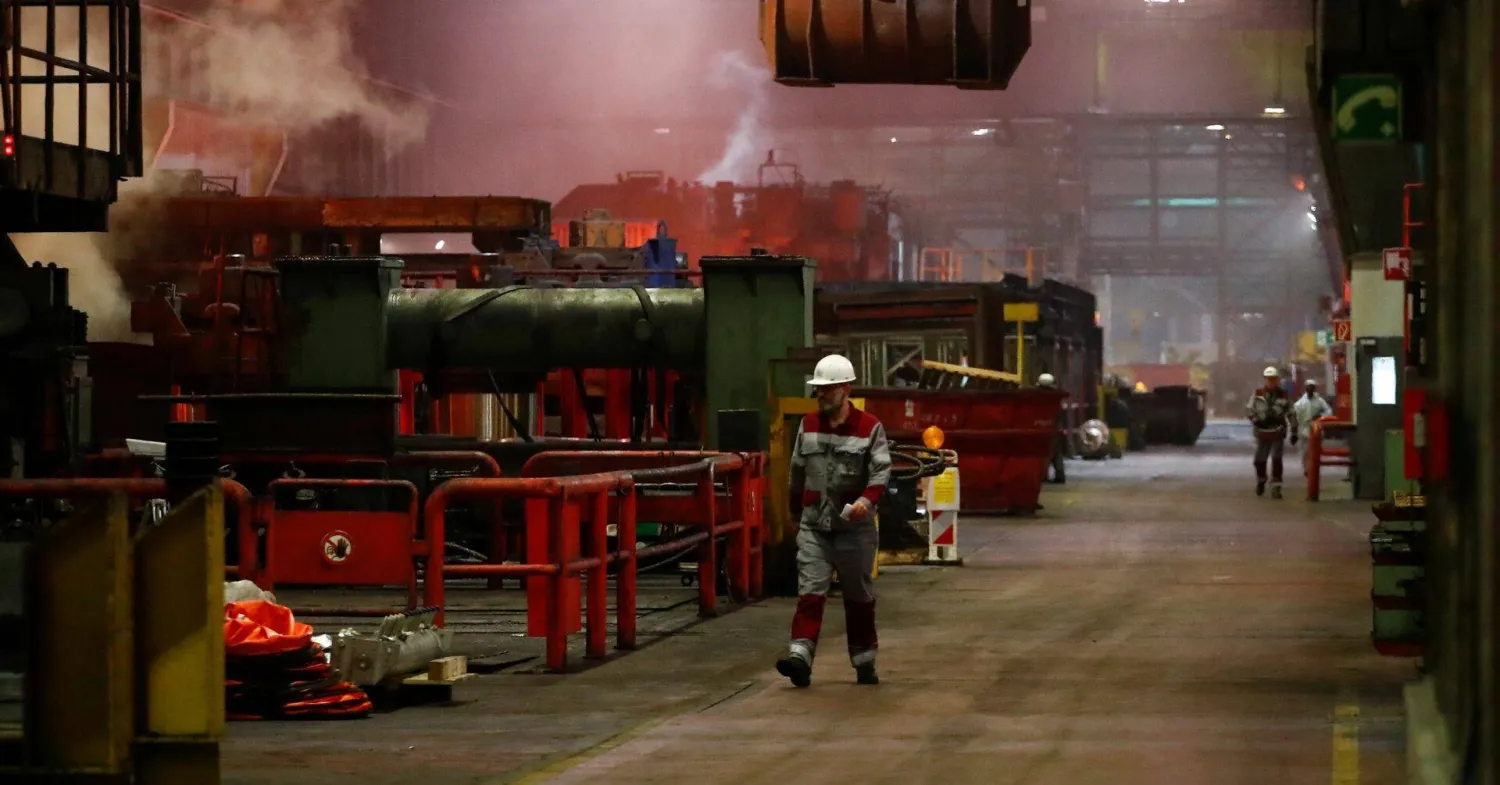 عمال في شركة «تيسنكروب» يسيرون في مصنع الصلب التابع للشركة في دوسلدورف (رويترز)