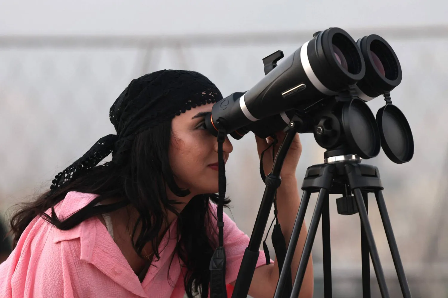 سيدة إيرانية تشاهد مراحل خسوف القمر الكلي عند جسر الطبيعة في طهران (أ.ف.ب)