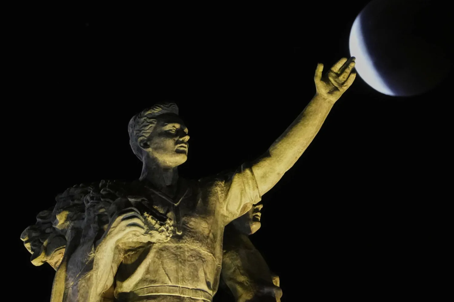 ويتحول لون القمر إلى الأحمر أثناء انزلاقه إلى ظل الأرض الذي يحجب أشعة الشمس ويفقد تدريجياً بريقه الأبيض (أ.ب)
