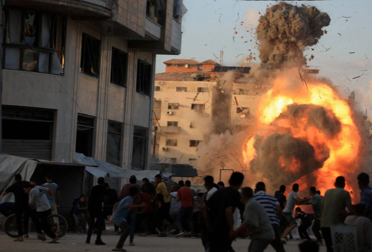 تصاعد الدخان وألسنة اللهب أثناء انهيار مبنى سكني بعد غارة جوية إسرائيلية في مدينة غزة (رويترز)